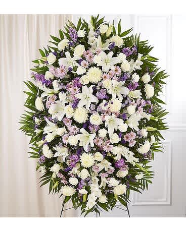 Lavender &amp; White Spray - When words alone cannot convey the feelings in your heart, flowers can provide a meaningful and profound statement. Our impressive standing spray arrangement is meticulously handcrafted by expert local florists with soothing lavender and white blooms for a lush, full presentation, presenting an elegant and memorable tribute. Standing spray arrangement with lavender daisy poms, stock and monte casino; white roses, Oriental lilies, football mums, gladiola and carnations; purple statice; accented with soft, lush greenery Arrives on an easel Appropriate for the funeral home or gravesite Our florists hand-design each arrangement, so colors and varieties may vary due to local availability