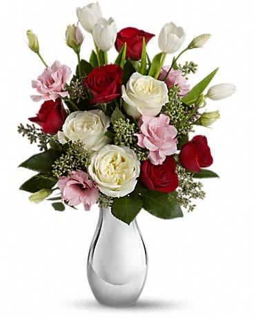 Teleflora's Love Forever Bouquet with Red Roses - Tickle her heart with this flirtatious mix of romantic roses, lisianthus and tulips. This bouquet is arranged in our elegant Silver Reflections vase. It's a vase she's sure to hold on to - and it'll always remind her of you. This feminine bouquet features large white and red roses, delicate pink lisianthus, elegant white tulips and seeded eucalyptus and comes delivered in our exclusive Silver Reflections vase, a metalized ceramic vase with a light pink tone.