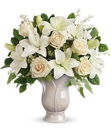 Teleflora's Wondrous Life Bouquet - Celebrate a wondrous life with this timeless tribute of pure white lilies and roses, arranged in a graceful tulip-shaped ceramic vase. This monochromatic bouquet features crÃ¨me roses, white asiatic lilies, seeded eucalyptus, and lemon leaf. Delivered in a Blooming Tulip vase.