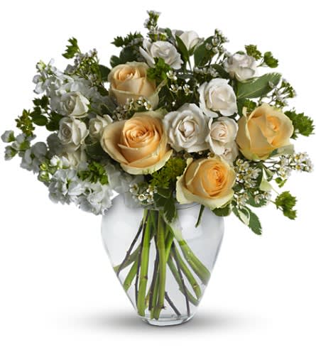 Celestial Love - Peaceful and pure. This pretty arrangement of white and light colors will let anyone know they are in your thoughts. Fresh flowers such as peach roses creme spray roses white stock waxflower and more are gathered in a beautiful clear vase.  The bouquet pictured reflects our original design for this product. While we always try to follow the color palette, we may replace stems to deliver the freshest bouquet possible, and we may sometimes need to use a different vase.  