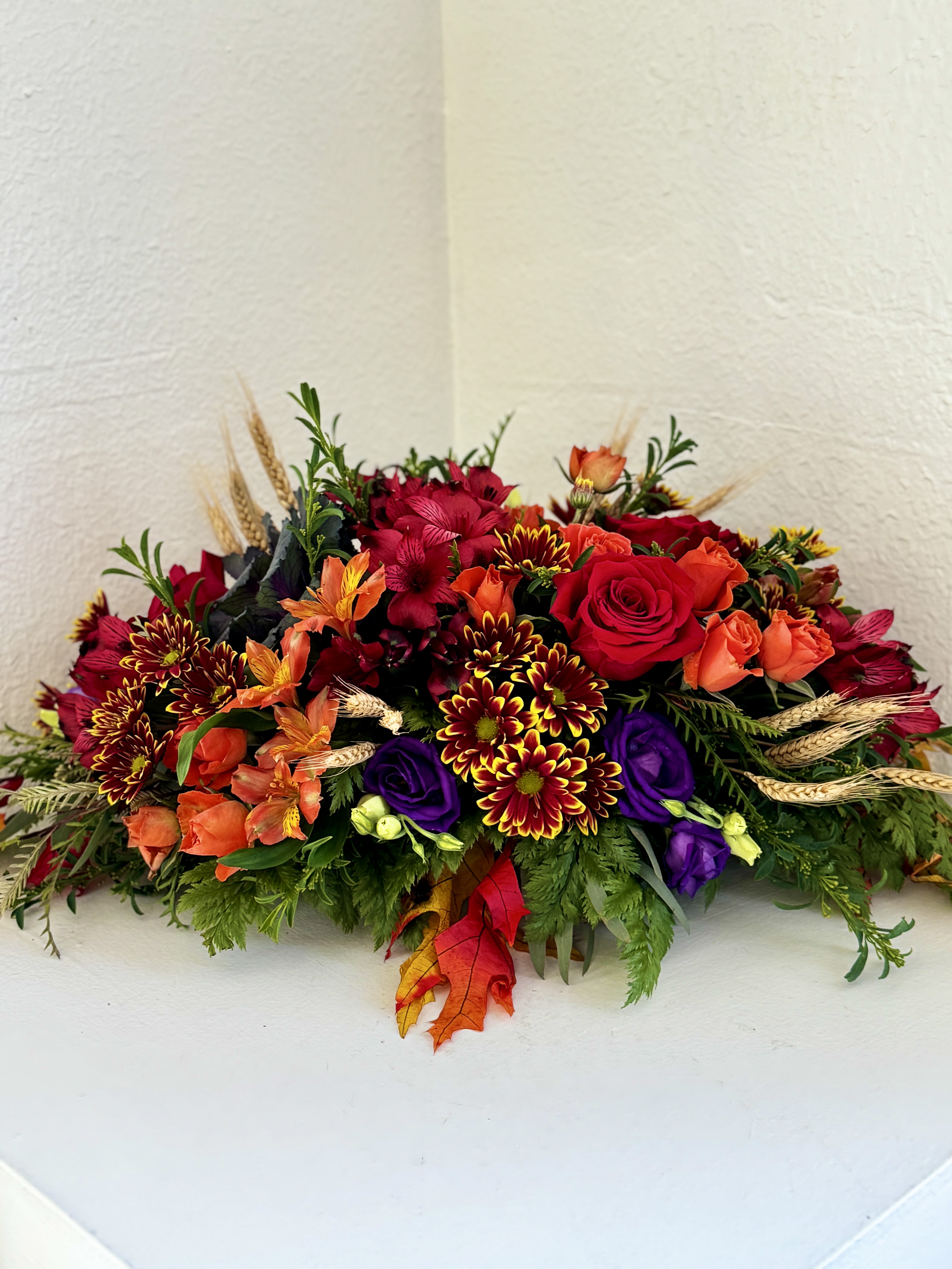 Fall Sunset Centerpiece - Elevate your or your loved one's tablescape with this elongated centerpiece filled with a gorgeous mix of red, orange, and purple blooms! 