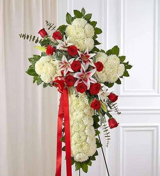 Red Rose &amp; Lily Standing Cross - The Red Rose &amp; Lily Standing Cross by DGM Flowers | Fort Lauderdale Florist is a stunning tribute for a funeral. This elegant funeral standing floral cross features fresh white mums designed with a vibrant cascade of rich ruby red roses and majestic Stargazer lilies. A heartfelt expression of sympathy and faith, this tribute will serve as a memorial to a family member who inspired faith and love.&nbsp; &nbsp;  We hand-design each arrangement, so colors and varieties may vary due to local availability Arrangement of mums, roses, Stargazer lilies, spiral and seeded eucalyptus and salal Arrangement measures approximately 40&quot;H x 30&quot;L without easel Appropriate to send to the funeral service