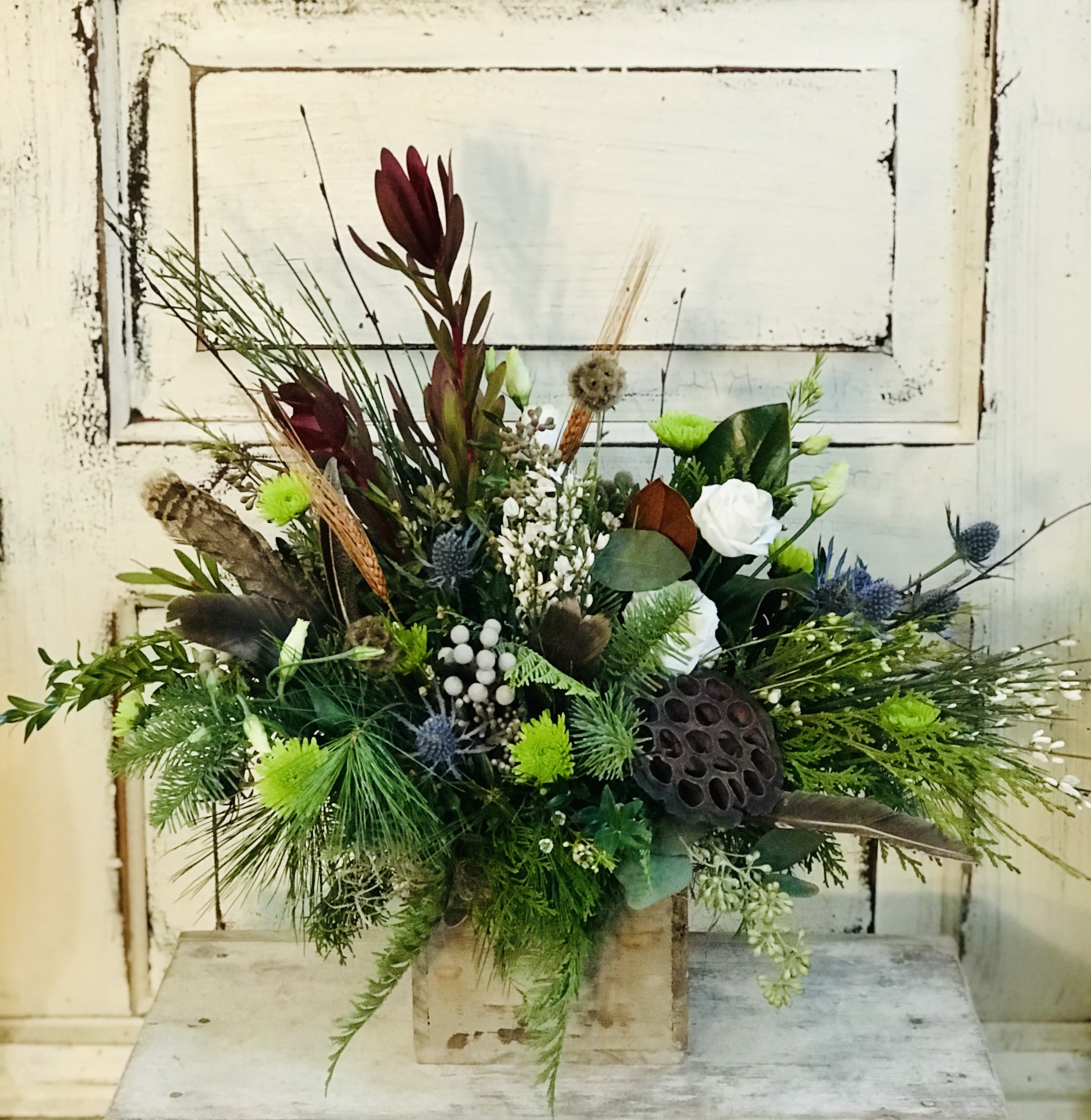 Nature Lover - Unique foliage, lotus pods, pheasant feathers branches and blooms make a natural statement for the winter season. The wooden box is 4x4&quot;.