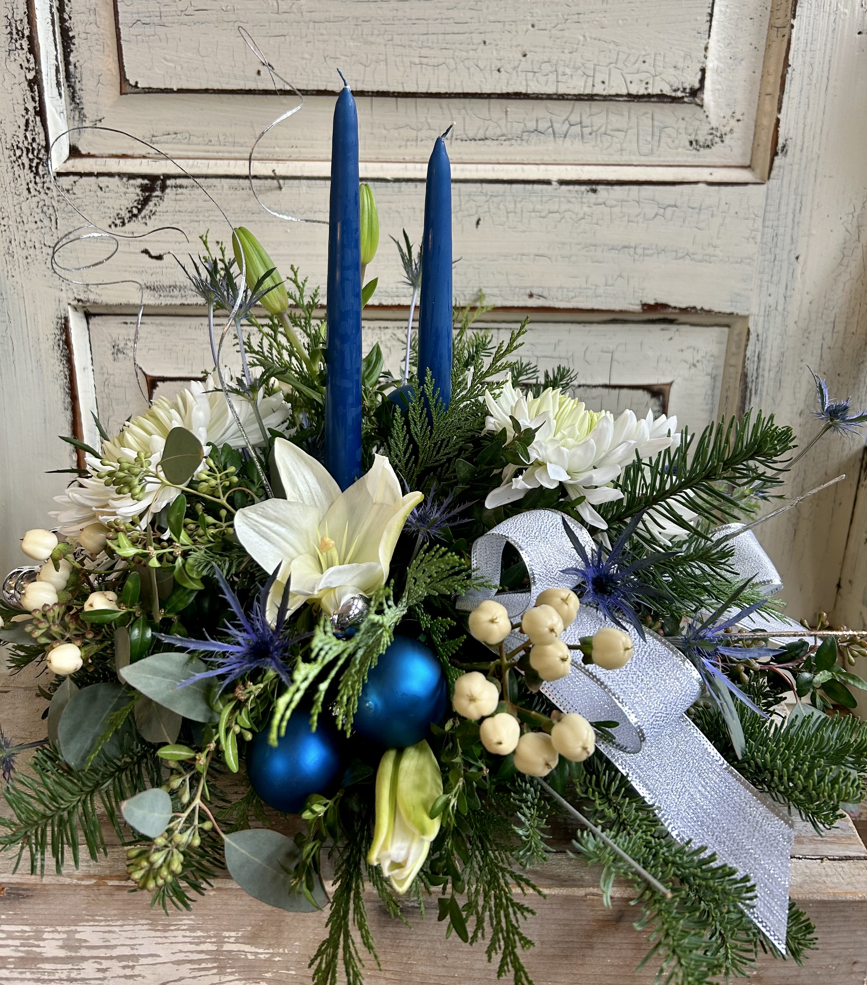 Blue &amp; White Centerpiece - Blue taper candles, blue and silver ornaments and gorgeous fresh white blooms accompany assorted evergreens in a low dish. 