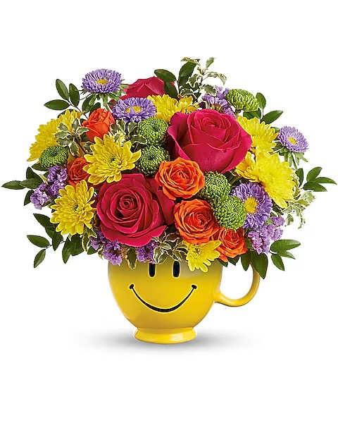 Teleflora's Choose Happy Bouquet - Smile, you've got flowersâ¦and a mug! Brighten their day with a burst of colorful roses and a smiling ceramic mug. Hot pink roses, orange spray roses, lavender matsumoto asters, green button spray chrysanthemums, yellow cushion spray chrysanthemums and lavender sinuata statice are arranged with huckleberry and pitta negra. Delivered in a Be HappyÂ® Mug.