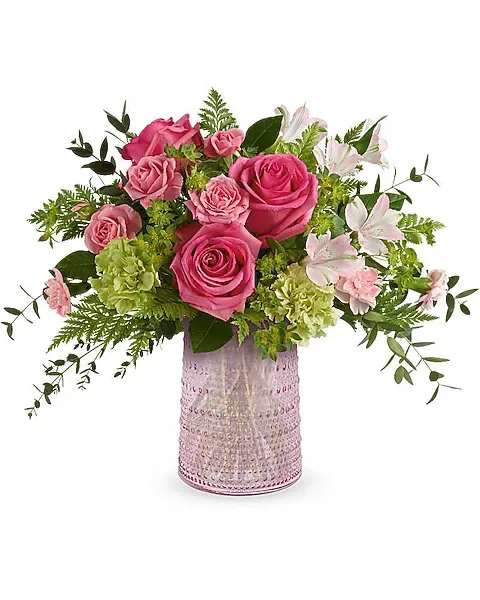 Teleflora's Sparkling Joy Bouquet - Delight Mom with the Sparkling Joy Bouquet, delivered in a pink glass carafe with elegant beaded details. Paired with hot pink roses, pink spray roses, light pink alstroemeria, and other pretty blooms, this keepsake meets FDA tableware standards to safely serve and store drinks, adding beauty to any table year-round. Surprise her with the Sparkling Joy Bouquet-hot pink roses, pink spray roses, light pink alstroemeria, green carnations, pink miniature carnations, bupleurum, leatherleaf fern, and parvifolia eucalyptus-artfully arranged in the food-safe pink glass carafe with elegant beaded details, a cherished gift for Mom.