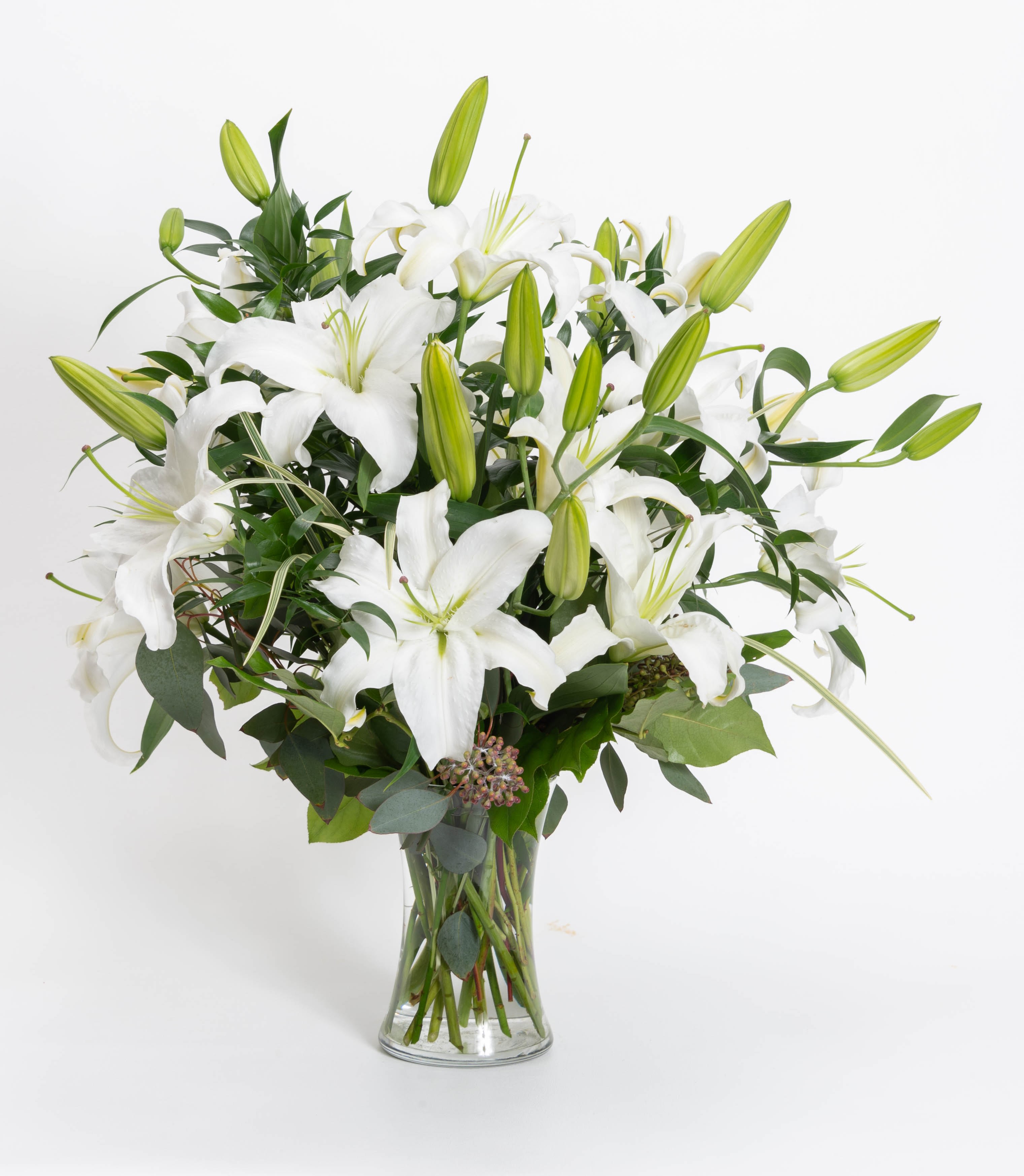 White oriental lily - A vase of all white oriental lilies with decorative greens. 