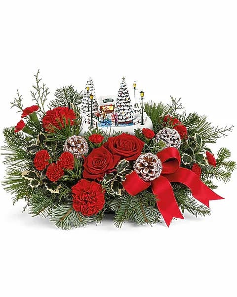 Thomas Kinkade's Oh What Fun Bouquet - Celebrate the season with this delightful Thomas Kinkade collectible, nestled among festive red roses and winter greens-a memorable gift that lights up with a classic ice skating scene for extra holiday joy. Celebrate the holidays with Thomas Kinkade's Oh What Fun arrangement. It includes vibrant red roses, classic red carnations, and miniature red carnations, accented with variegated holly, noble fir, white pine, and cedar. Delivered in Teleflora's charming Thomas Kinkade's Oh What Fun Keepsake, it makes a festive seasonal centerpiece.