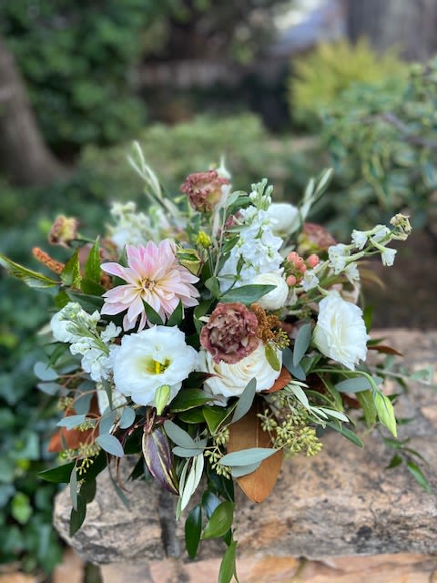 Keep it Neutral - Light shades of blush, browns, and white make for an elegant statement with these sweet and delicate garden blooms. Featuring delphinium, lisianthus, stock, roses, and ranunculus in a brown ceramic container. 