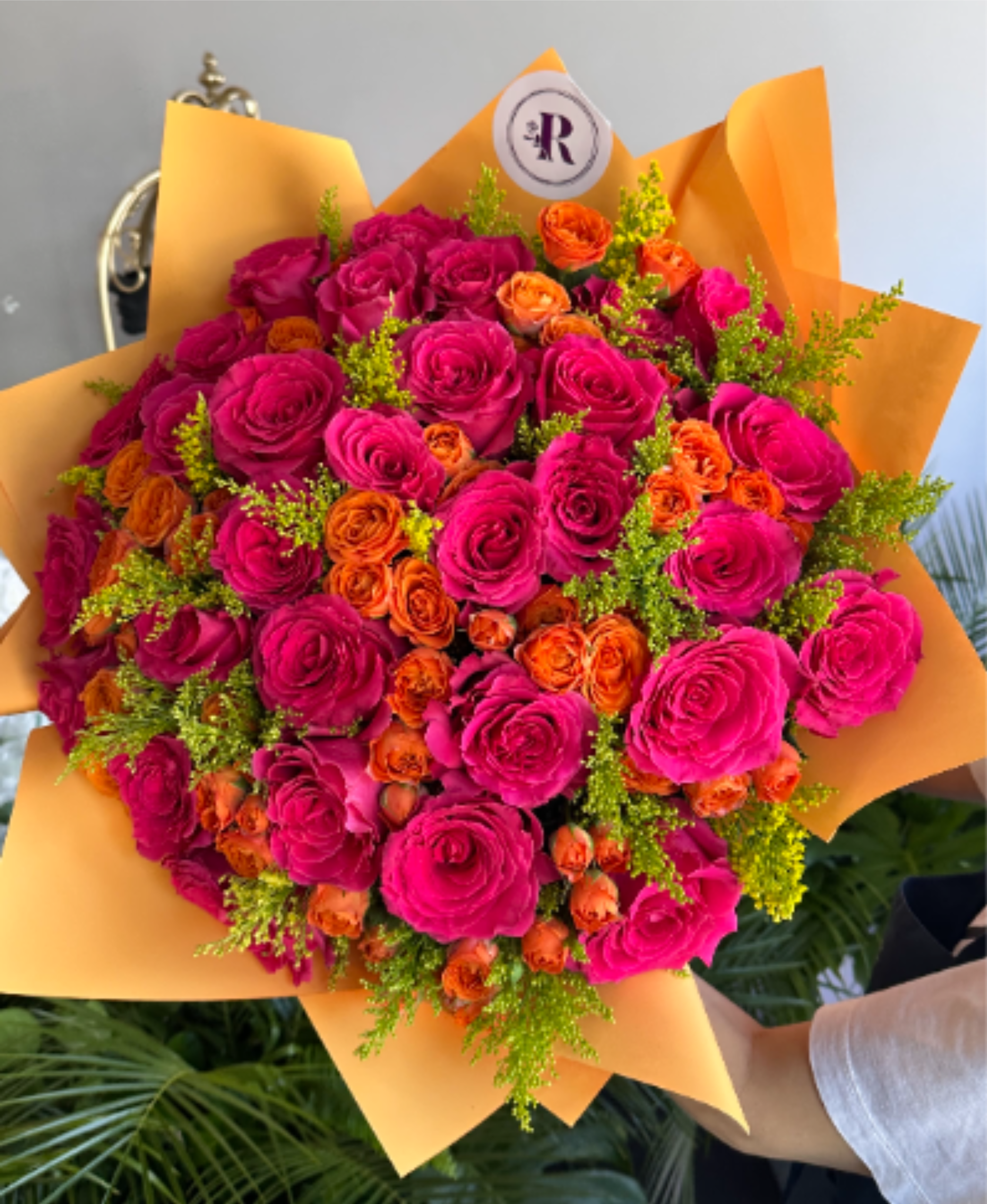 Autumn Radiance - A radiant fall bouquet featuring fuchsia colored and orange roses, golden solidago, and lush seasonal greenery. Handcrafted by our West Hollywood florists, this elegant design captures the warmth of autumn. Perfect for Thanksgiving gifting and any occasion. Same-Day Delivery is usually available in white, red, peach, and pink. This bouquet comes without a vase. You can select a glass vase from the add-ons shown. SEASONAL or unavailable colors can be replaced with similar ones. DELUXE size is shown in the main picture.