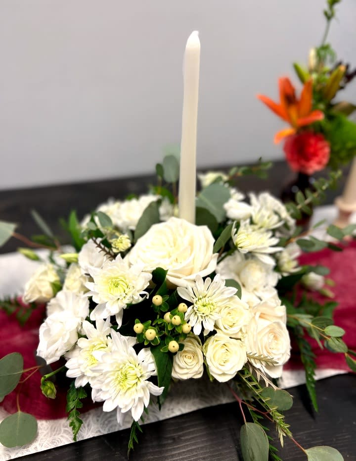 Farmhouse Holiday Centerpiece - The Farmhouse Holiday Centerpiece features variety of roses, and blooms filler flowers in shades of white. Includes a dinner candle, this centerpiece is lovely to look at from any seat at the table . Send it as a housewarming gift or for somebody's holiday dinner.  REGULAR APPROXIMATE DIMENSIONS 12&quot; W X 12&quot; H  