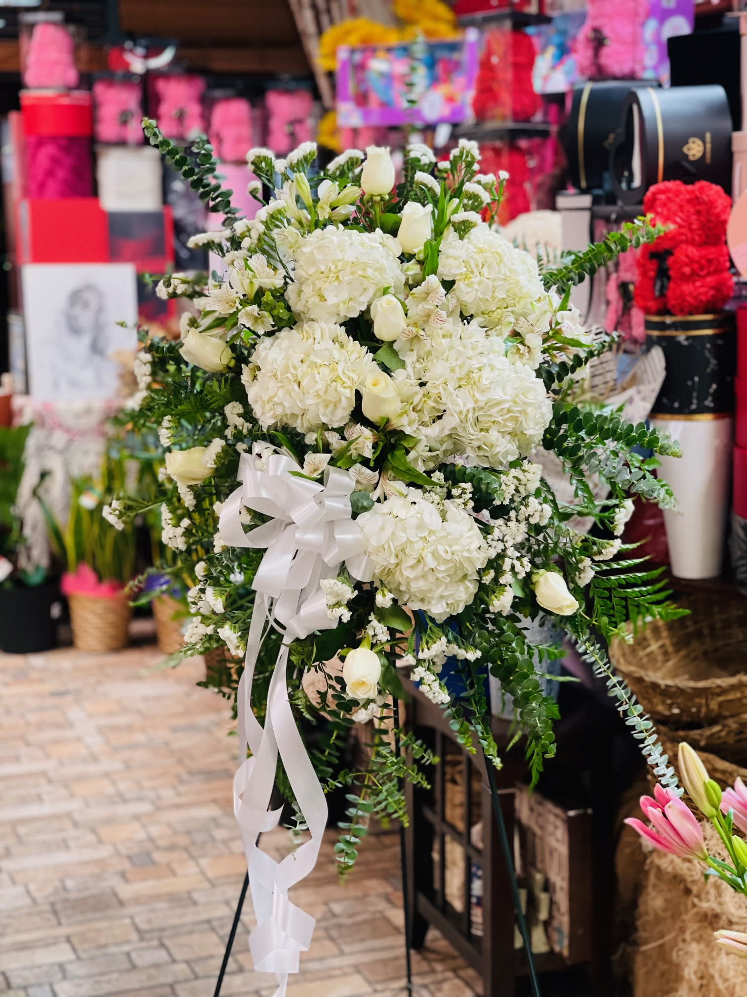 Ivory Celebrations - A classic full-standing spray in white with assorted flowers and greenery. Colors may be changed or added to ensure they represent your loved ones appropriately. Let us make your loved one's memorial special with our carefully made arrangemetn. 