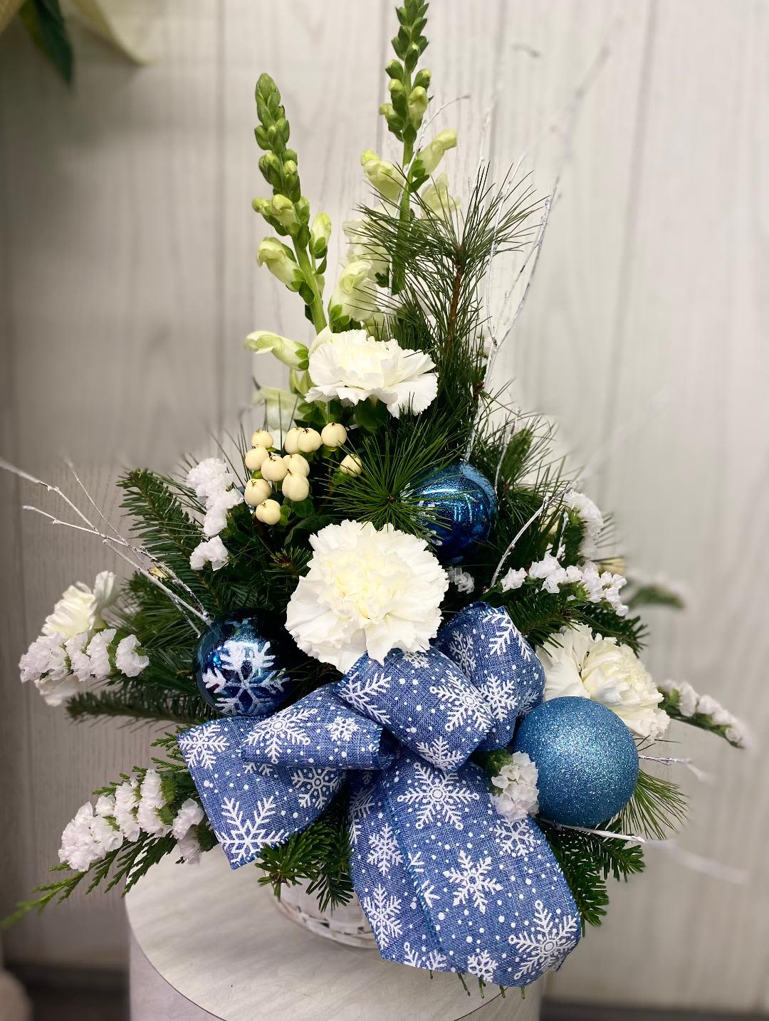 Winter Lights Basket Arrangement - Celebrate the season with this festive holiday basket in blues &amp; whites. Approximately 15 inches high. Flowers may be substituted based on current inventory. The overall look, feel and value will be maintained. Deluxe &amp; premium include more flowers.