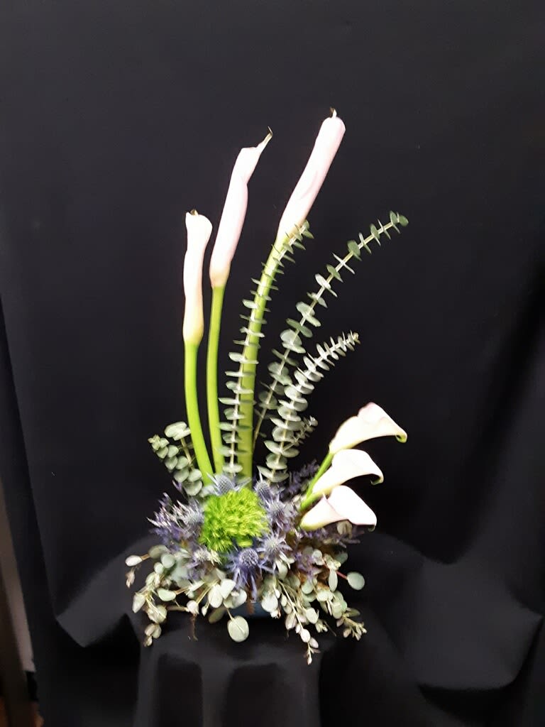 Shooting for the stars - All white high style arrangement calla lilies, dianthus, thisel with mixed eucaliptus