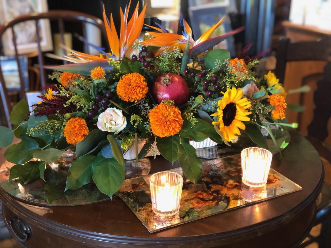 Thankful Appreciation - Birds of paradise crown this centerpiece surrounded by fall favorites; sunflowers, orange marigolds, deep burgundy hypericum, delicate blush lisianthus and of course fresh pomegranates 