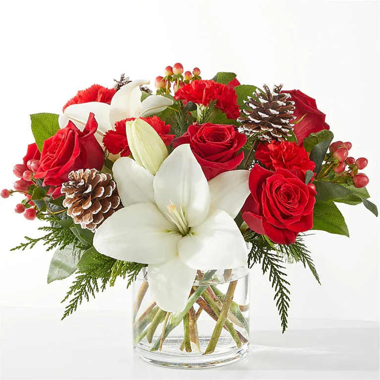 Oh So Jolly Bouquet - This bouquet is sure to shimmer as bright as the holiday lights with lush carnations, roses, and lilies bursting from the vase.