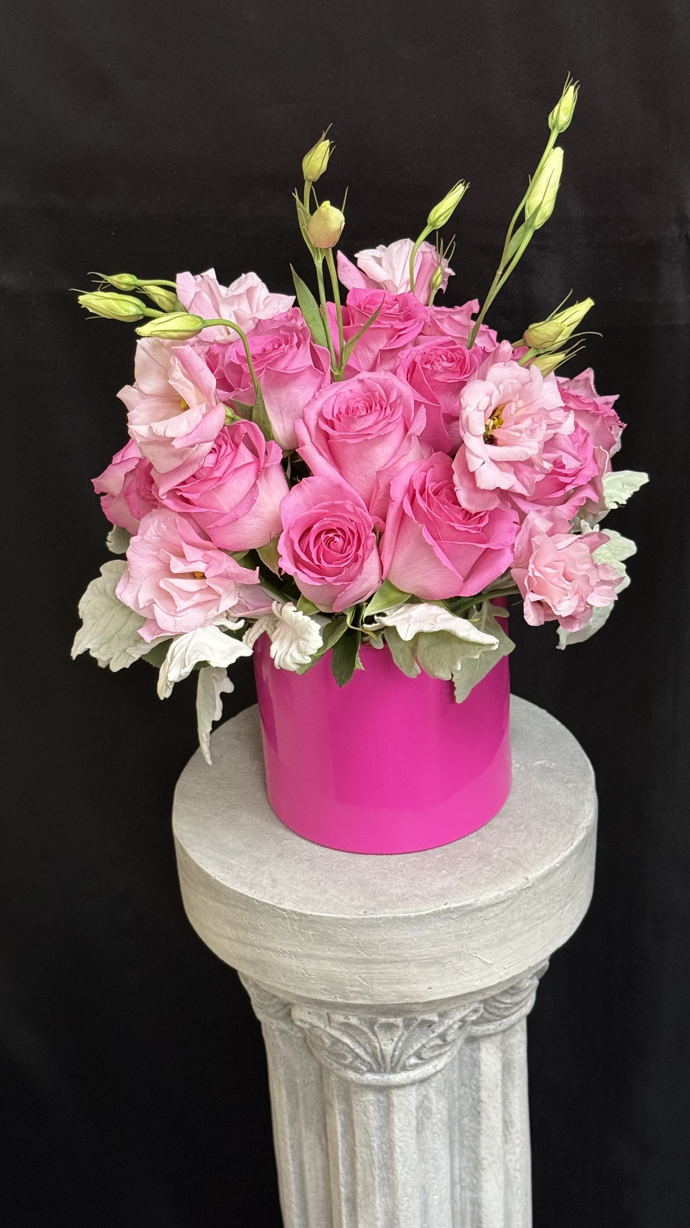 Pink Passion Bloom - A radian mix of fuchsia and blush pink 12 roses paired with delicate lisianthus blooms and velvety dusty miller foliage. Arranged in a bold pink vase, this vibrant composition evokes love, charm, and confidence _perfect for celebrating milestones, birthdays, or simply making someone's day beautiful unforgettable.