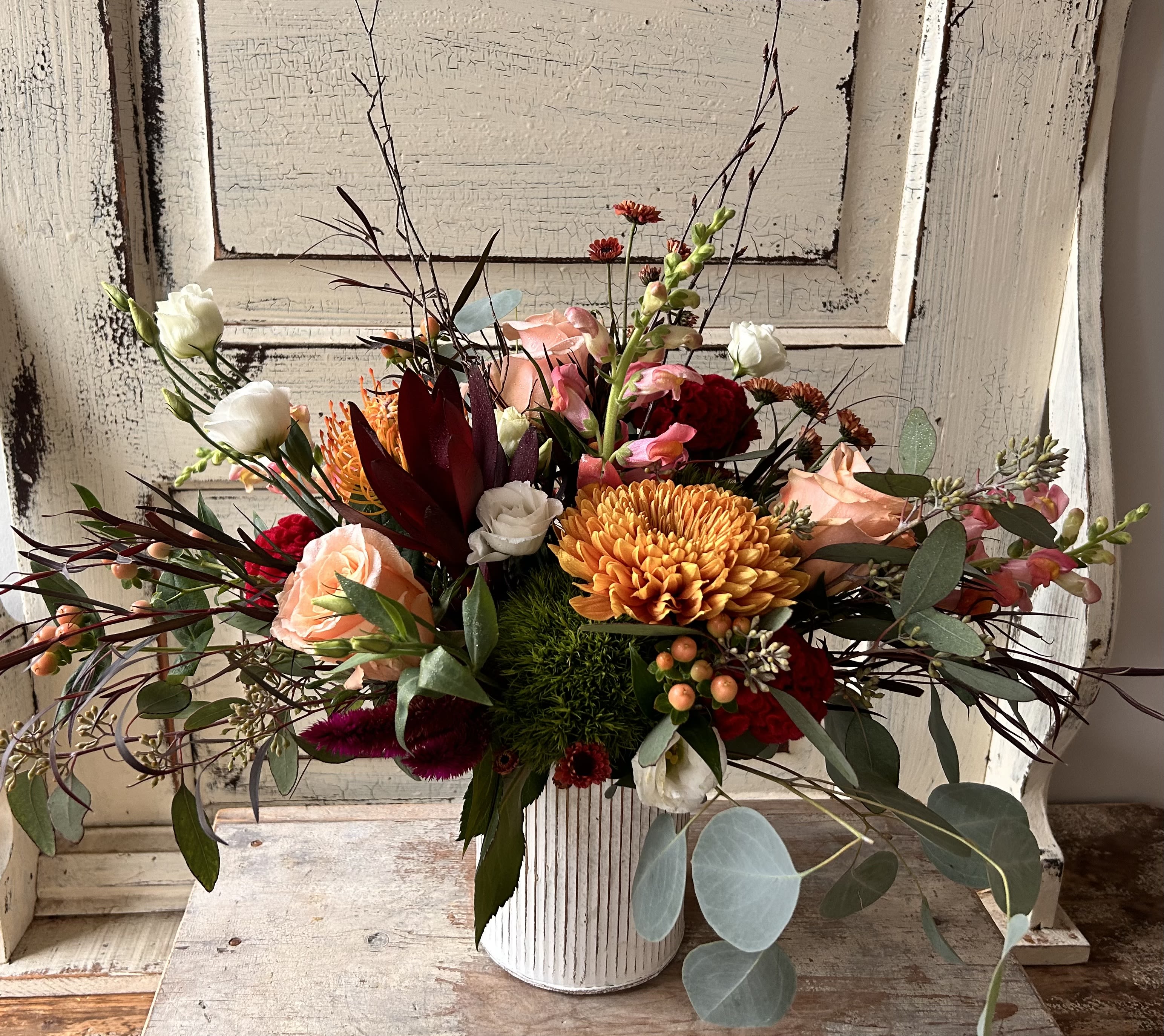 Subtle Autumn  - A white washed metal cylinder is arranged with a unique texture-laden design that includes a seasonal assortment of fresh flowers, dried materials and foliage. This design is a softer nod to autumn.