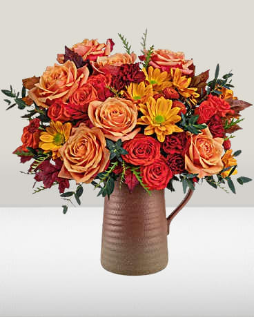 Terra Bloom Bouquet - Celebrate fall with Terra Bloom Bouquet, a stunning mix of autumn flowers in a rustic stoneware pitcher. With rich orange and maroon hues, this seasonal arrangement is perfect for Thanksgiving décor or a warm harvest gift