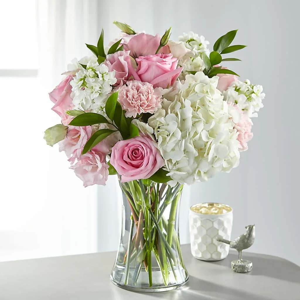 Guiding Grace Bouquet - Share comfort, love and solace with a bouquet designed with blushing pink and pure white blooms. An array of hydrangea, stock, roses and lisianthus come together in a glass vase to create our Guiding Grace Bouquet.