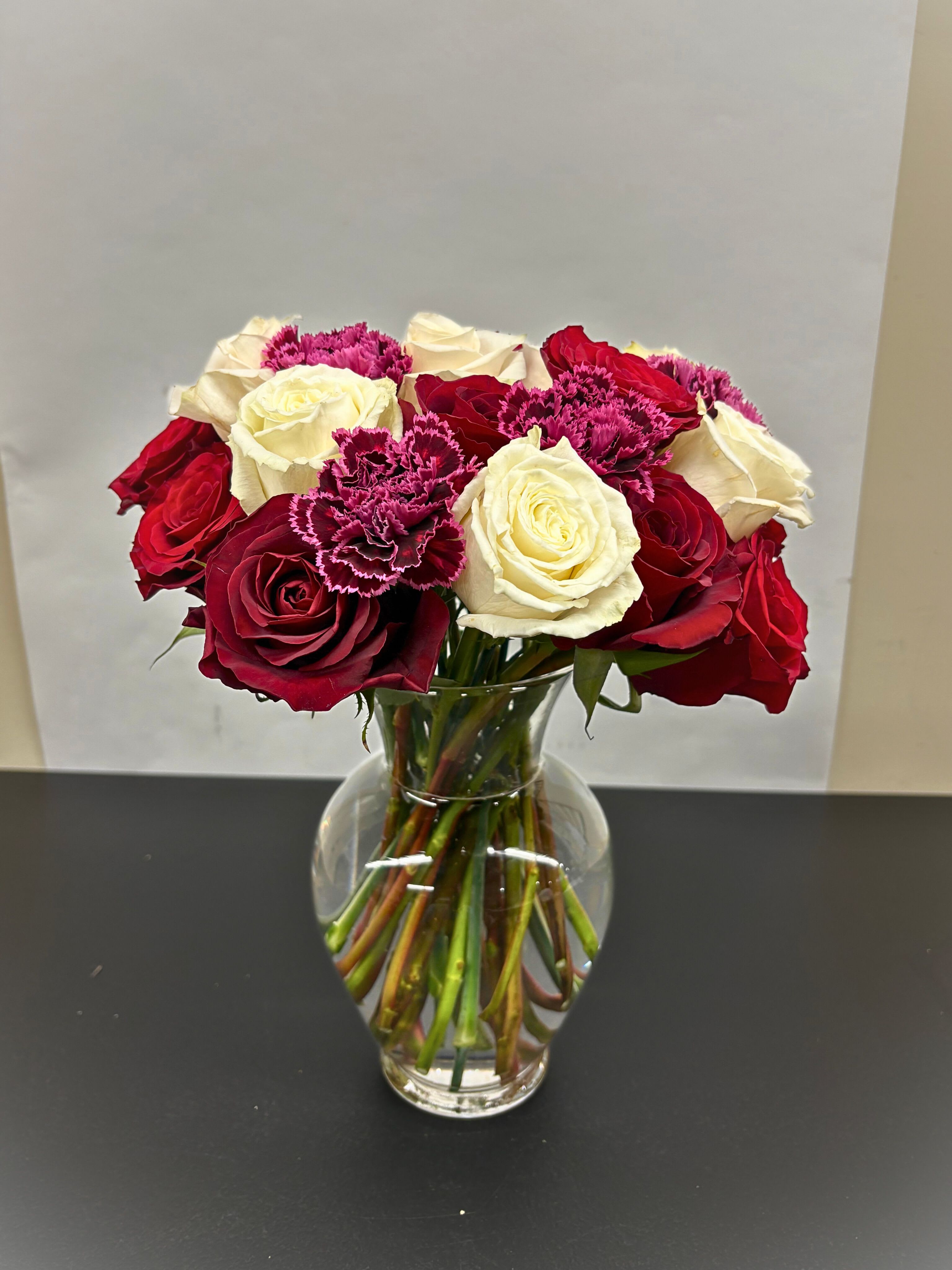 Stunning Roses - This arrangement includes Red, White and Pink Roses, with a seasonal focal to emphasize the roses elegance. Standard, Deluxe, and Premium feature 18, 24, and 30 Roses respectively