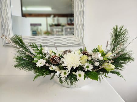 Holiday Wow #3 - This elegant arrangement is designed with stunning white blooms, fresh mixed greenery and silver accents into a silver, modern boat-shaped container.