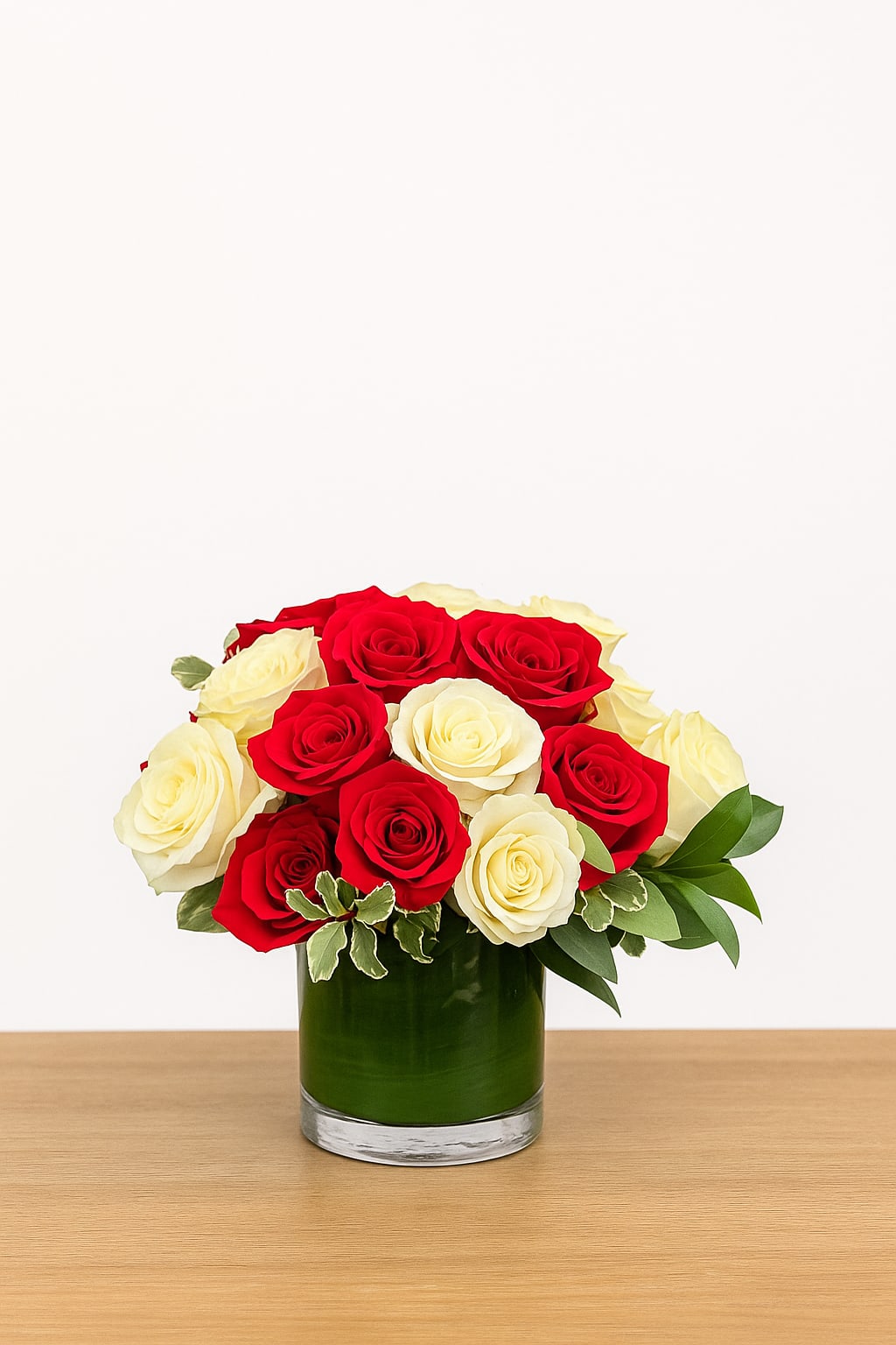 Red and White Roses - Classic and romantic, Red and White Roses features a stunning mix of premium blooms arranged in a modern glass vase. The deep red roses symbolize love and passion, while the creamy white roses represent purity and grace — a perfect balance for any occasion. Thoughtfully designed with lush greenery, this arrangement adds timeless elegance to any space.  Elegant. Refined. Designed with love in San Francisco by Polk Street Florist.  