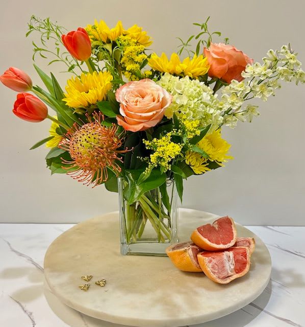 Tangerine Splash - A burst of vibrant energy and warmth, this arrangement captures the refreshing essence of citrus. With lively tangerine tones and bold blooms, it adds a splash of brightness to any space. Please note, tulip and flower colors may vary based on availability, but the vibrant look and feel will remain the same.