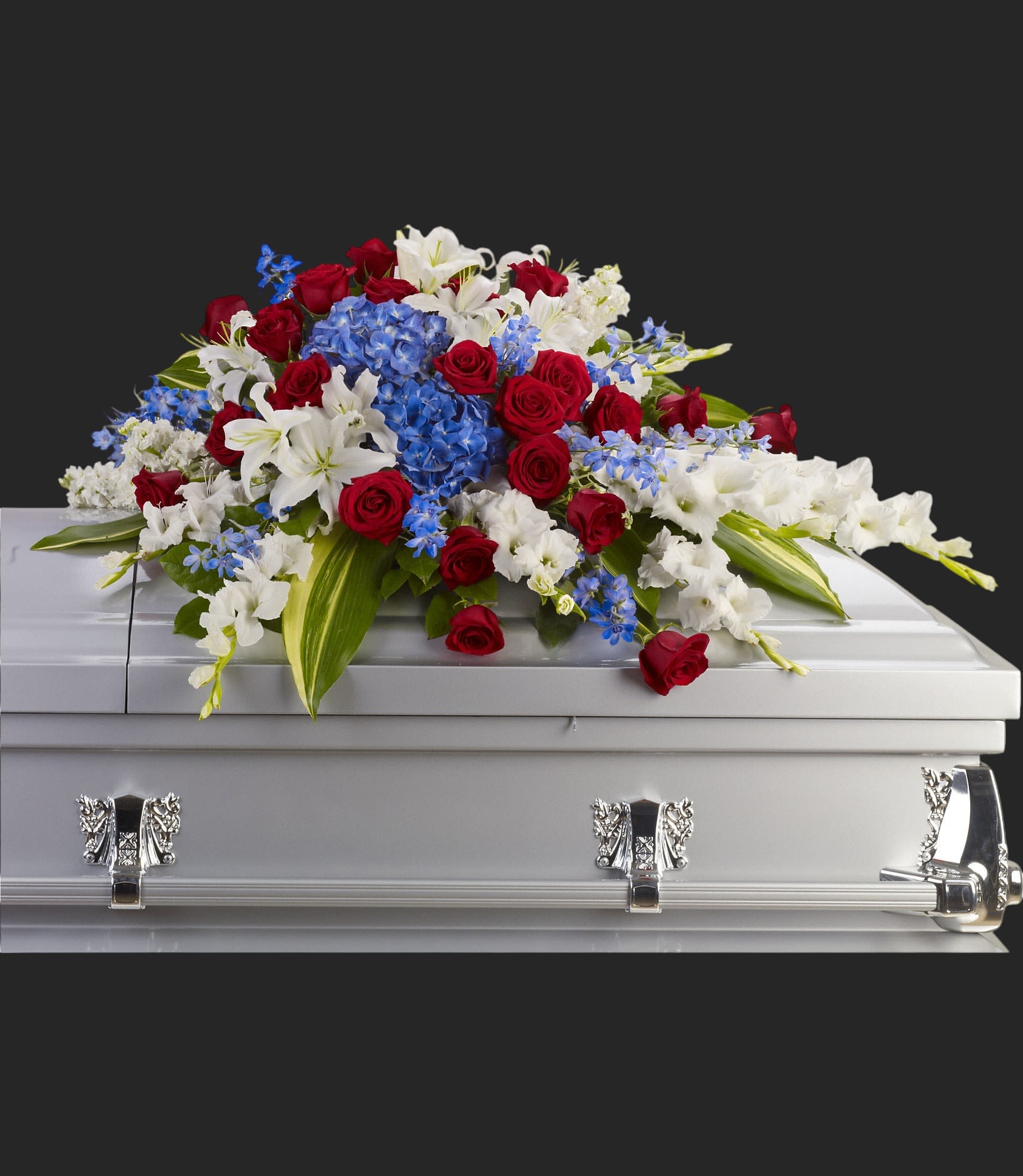 Distinguished Service Casket Spray by Teleflora - A beautifully patriotic way to pay tribute to a loved one. This half-couch spray sends an eloquent message of strength, respect and freedom.  