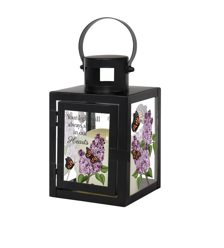 "In Our Hearts" Lantern - Small - Our small lanterns are made with a high-quality powder coated black metal finish. They come inscribed with sentimental quotes and a charming flameless LED candle. This lantern reads "Your light will always shine in our hearts." Suitable for hanging or use as a freestanding item. Recommended as an accent in floral arrangements for many occasions. They are weather friendly! Standard - Lantern with Bow Deluxe - Lantern with Floral Design Premium - Lantern with Robust Floral Design  
