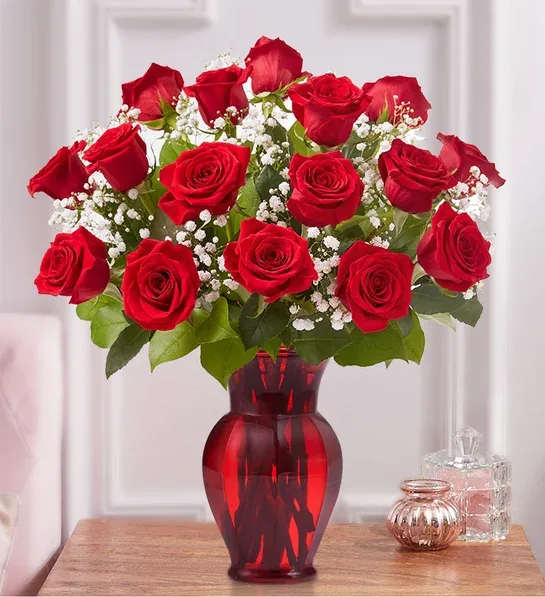 Blooming Love™ Premium Red Roses - Sometimes flowers speak louder than words…and our elegant red roses speak volumes! Beautifully hand-arranged with lush greenery inside our exclusive ruby red vase, each radiant bloom will help you express your love in the most romantic way possible.  All-around arrangement with premium red roses, baby’s breath and greens Our florists select the freshest flowers available, so colors and varieties may vary due to local availability Artistically designed in our exclusive ruby red glass vase; measures 8.75”H Deluxe arrangement of 18 red roses measures approximately 20&quot;H x 15&quot;L Standard arrangement of 12 red roses measures approximately 19&quot;H x 14&quot;L