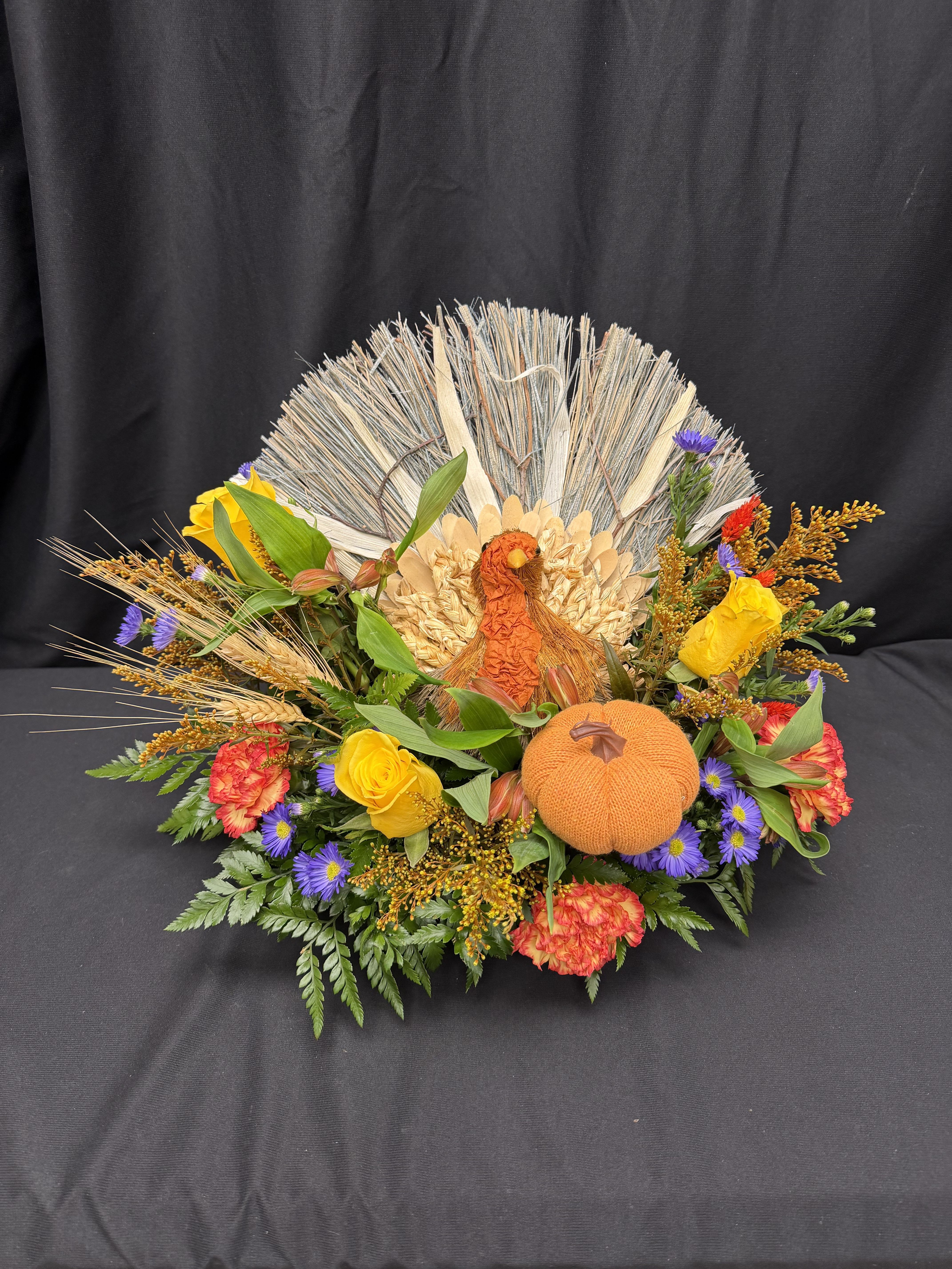 Gobble and Glow - Bring the warmth of the season to your table with our festive Gobble &amp; Glow centerpiece! Featuring a charming turkey keepsake surrounded by vibrant autumn blooms, golden wheat, and cheerful accents of orange and yellow, this design captures the heart of Thanksgiving. Perfect for adding a cozy, joyful touch to your holiday table or gifting to a gracious host.  Includes a reusable turkey keepsake — a glowing reminder of gratitude and gathering all season long.