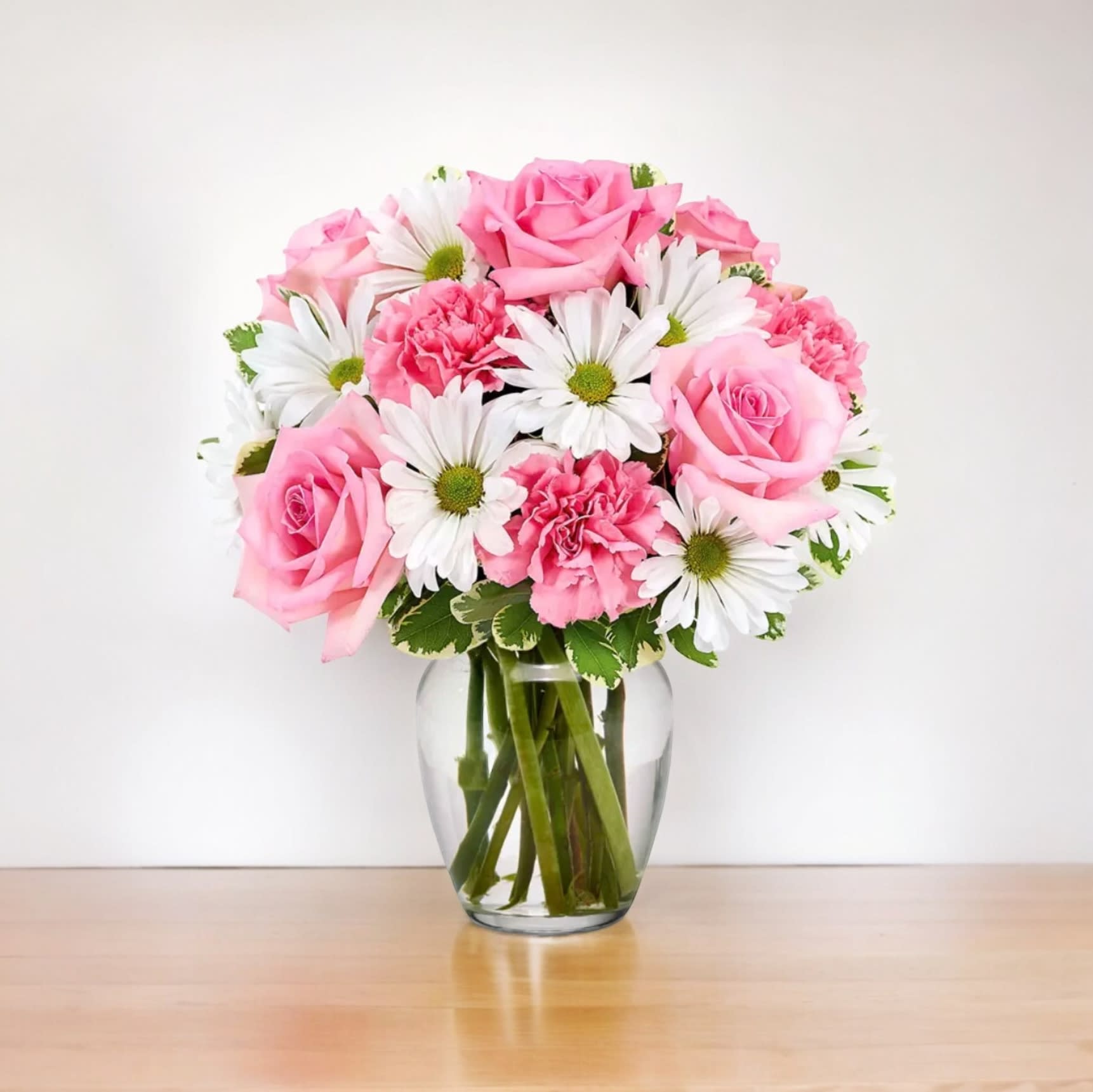 Daisy &amp; Rose Delight - Delight someone special in your life, or treat yourself (you deserve it!) to this undeniably charismatic combination of roses, daisy poms and carnations. A shimmering pink vase shows it all off, emphasizing and complementing the elegant mix of botanical colors.   Includes:  • Pink Roses (Deluxe and Premium Sizes Only)  • Pink Carnations  • White Daisies  • Seasonal Greens  • Delivery Today Available