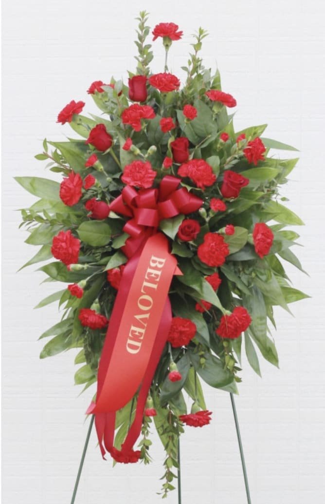 Classic Red Funeral Spray - Red Roses, Red Carnations, Wire Easel Our Classic Standing Spray features red roses, red carnations, seasonal greens, and a red bow. It's appropriate for funeral, memorial, and graveside services. Standard order does not come with a banner, 6 roses, 10 carnations, and greenery Delux Order Comes with a banner 6 roses, 10 carnations, 3 mini carnations, and greenery Premium Order comes with a banner 10 roses, 15 carnations, 6 mini carnations, and greenery  For add-ons and customs please call the store   