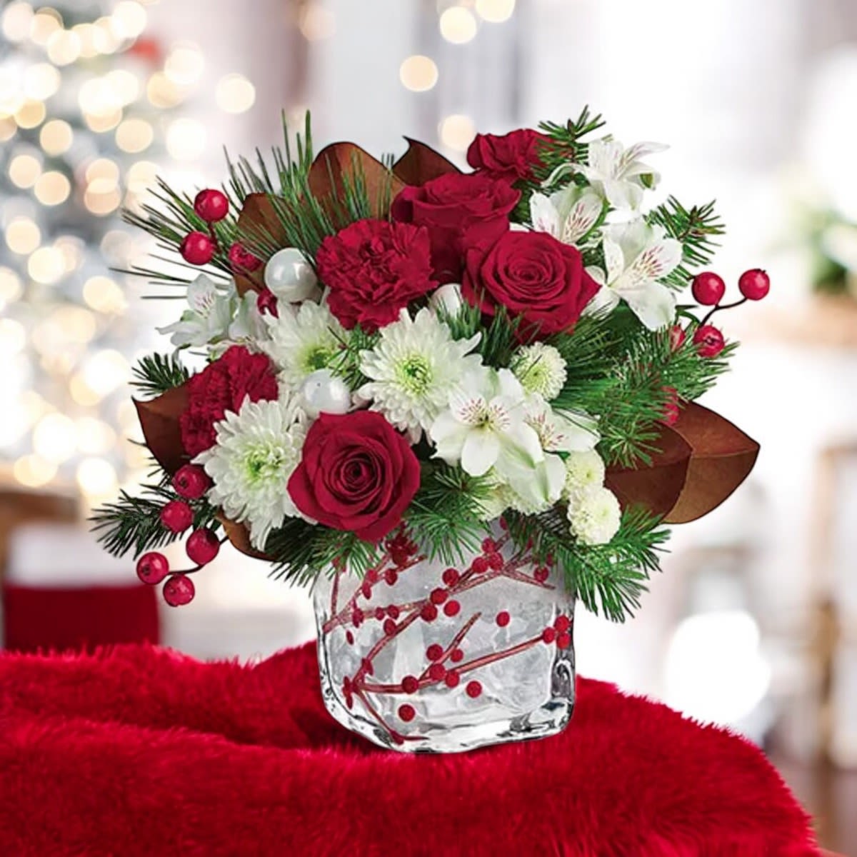 Christmas Berry Flower Bouquet - DESCRIPTION  One of our prettiest contemporary Christmas flowers arrangement, this mixed flower and berry bouquet is quaint, adorable, and oh so festive! Send this holiday centerpiece filled with fresh cut crimson rose and carnation, ivory chrysanthemum and alstroemeria to deliver your best seasonal wishes. Give them your best with a cherry display decorated with petite ornaments to make their celebration even more memorable! Hand delivered in an elegant berry glass vase, they can enjoy it as a keepsake afterwards to decorate for the season year after year. Details:  • Red Roses  • White Alstroemeria  • Red Carnations  • White Chrysanthemums  • Assorted Winter Greens