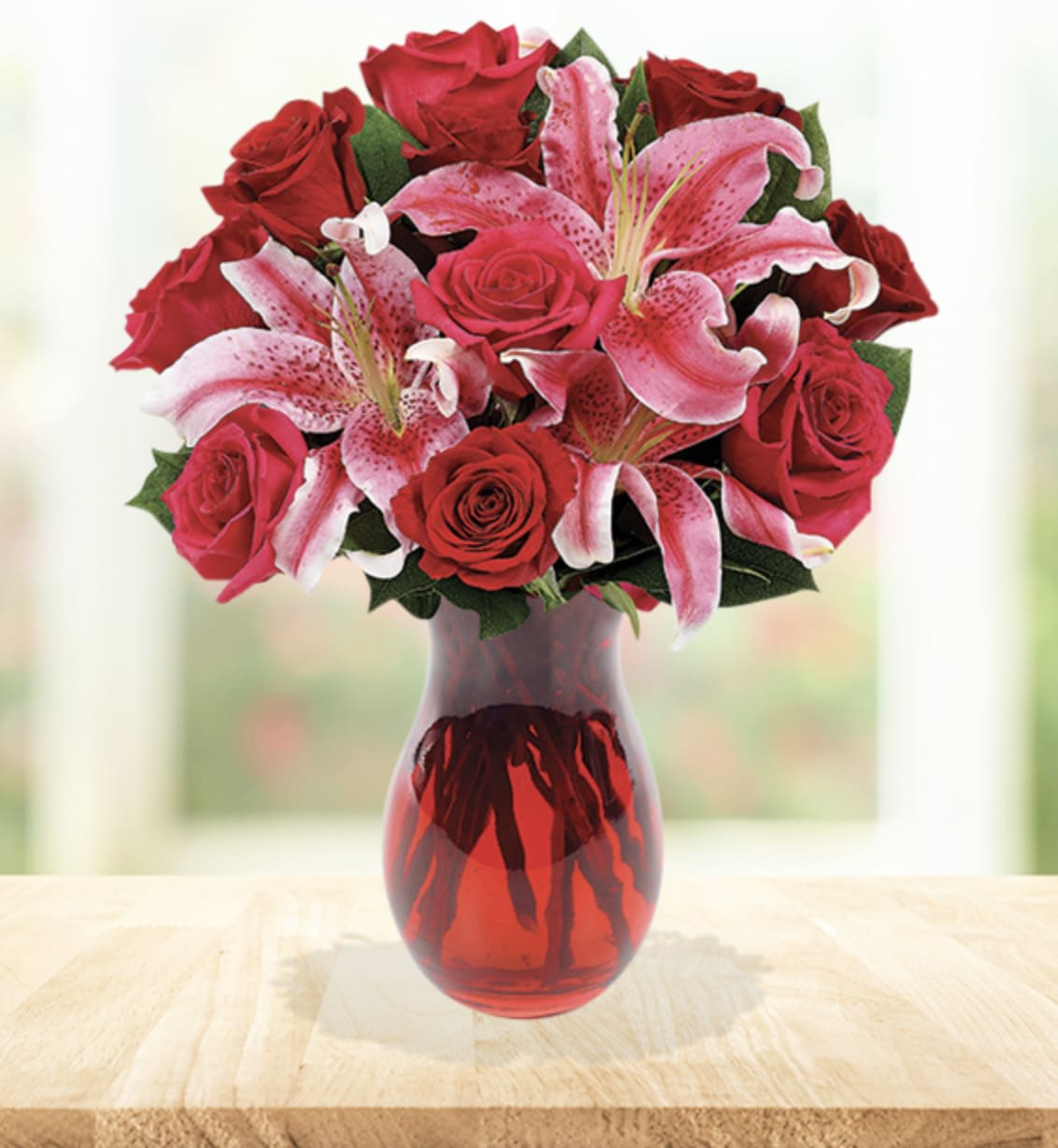 Perfect Impressions Bouquet - For a love that knows no bounds, lets the light in, and offers unexpected moments that you will each hold in your hearts on the path ahead, this bouquet is the perfect match. Lilies bring beauty and excitement to this elegant arrangement offset by a dramatic backdrop of rich red roses and carnations, all beautifully accented with lush greens and presented in a classic glass vase. A wonderful way to make that perfect impression and celebrate your love. Please note that some blooms may arrive in bud stage to ensure freshness.  Item pictured is a depiction of an arrangement that we will make as similar as possible with the same look and feel.