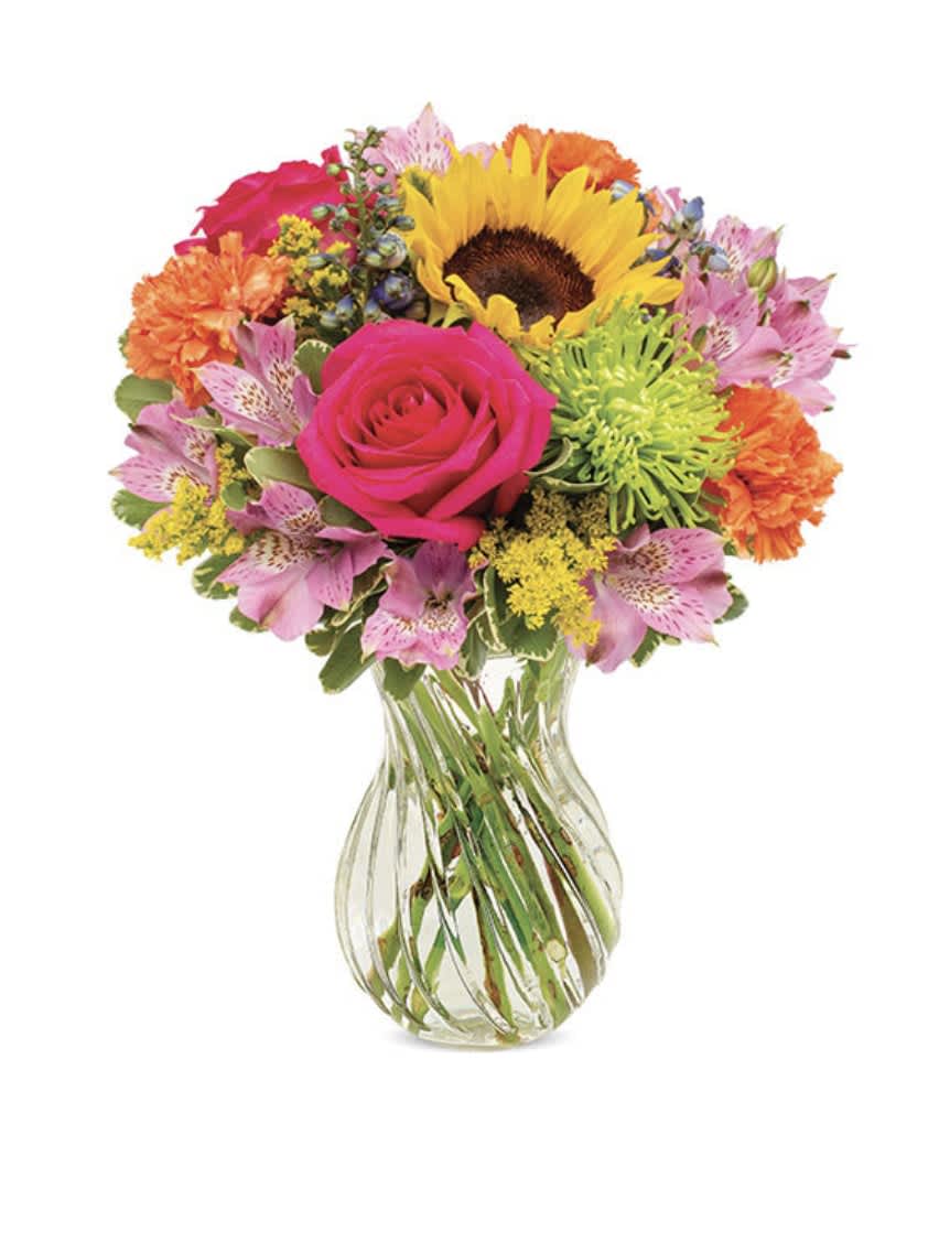 Blooming Meadow Bouquet - Transport yourself to a quiet morning as the sun splashes its rays on a peaceful meadow. That's the feeling this bouquet creates as sunflowers, roses, alstroemeria, carnations, fuji, delphinium and solidago are arranged in clear swirl vase. 