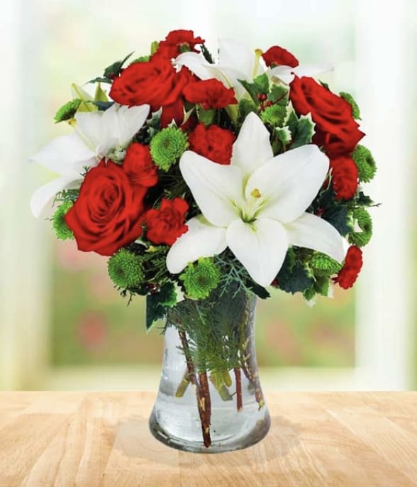 Christmas Treasure Bouquet - Treasure the festive holiday season with a bouquet to match the occasion! Our Christmas Treasure Bouquet is arranged with bold red roses, white lilies, mini carnations and button poms. Your recipient will absolutely love this elegant arrangement. 