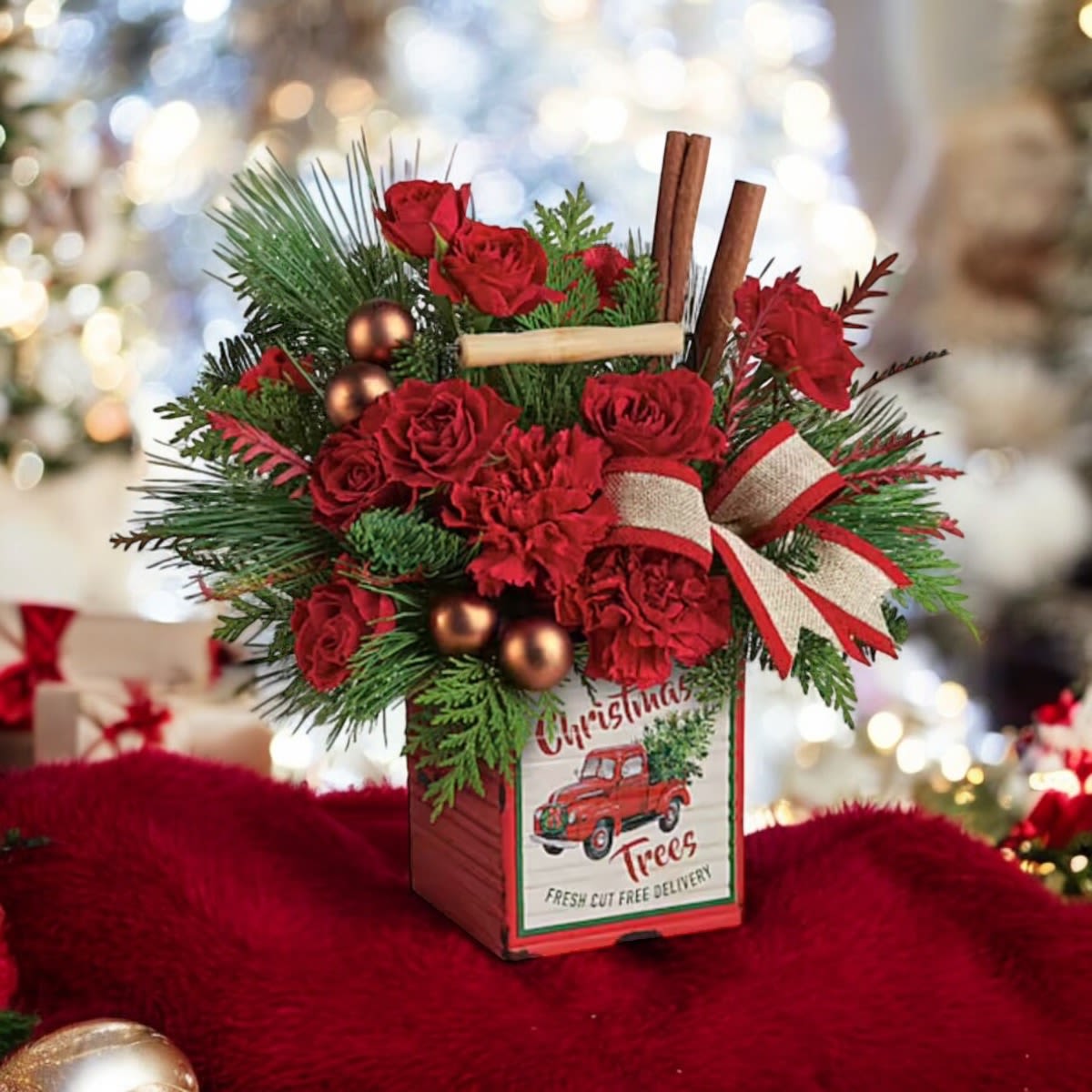 TELEFLORA'S MERRY VINTAGE CHRISTMAS BOUQUET - Wish them a merry vintage Christmas with a happy holiday bouquet of fresh blooms and winter greens delivered in this charming distressed metal cube! This merry arrangement includes red spray roses, red carnations, grevillea, flat cedar, noble fir, and white pine. Delivered in a Merry Vintage Christmas Cube.