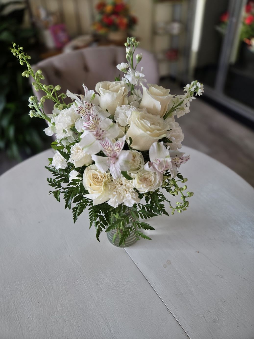 Still Bloom - A serene arrangement designed to offer comfort and peace. This elegant bouquet features soft white and cream blooms — including roses, carnations, and alstroemeria — complemented by fresh greenery. Its gentle beauty conveys heartfelt condolences and serves as a comforting reminder of love, remembrance, and support during difficult times.