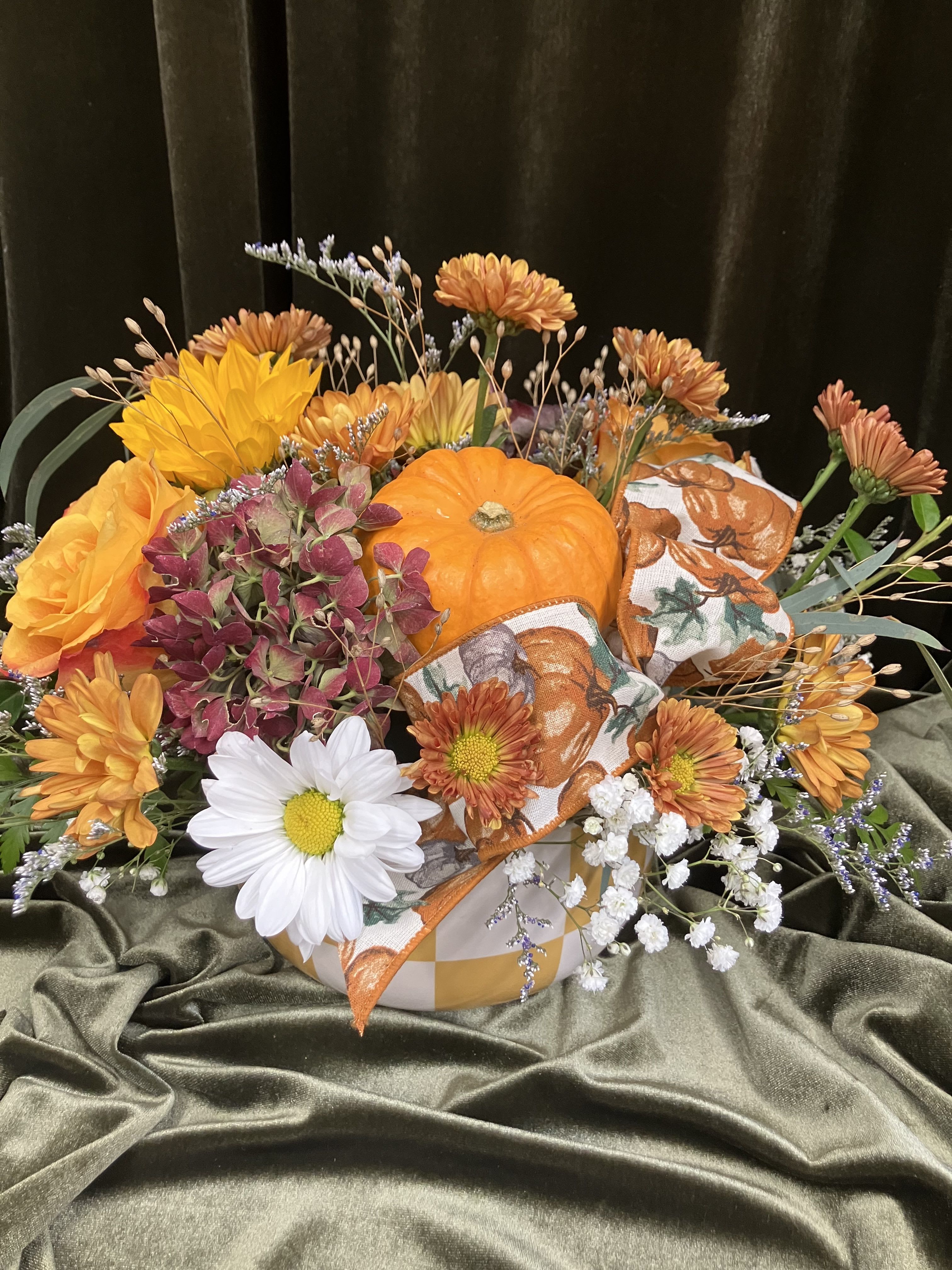 Fall Flowers  - Beautiful fall colors and flowers fill a cute ceramic container. Pumpkin ribbon and a decorative pumpkin bring a nice fall flair. 