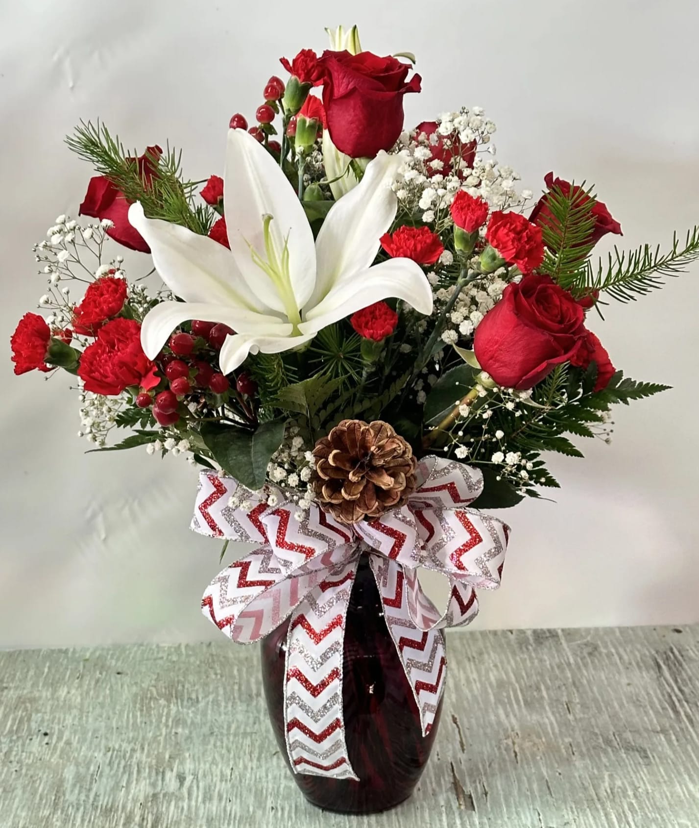 Christmas #2 - Arrangement of fresh cut flowers designed in a red vase.