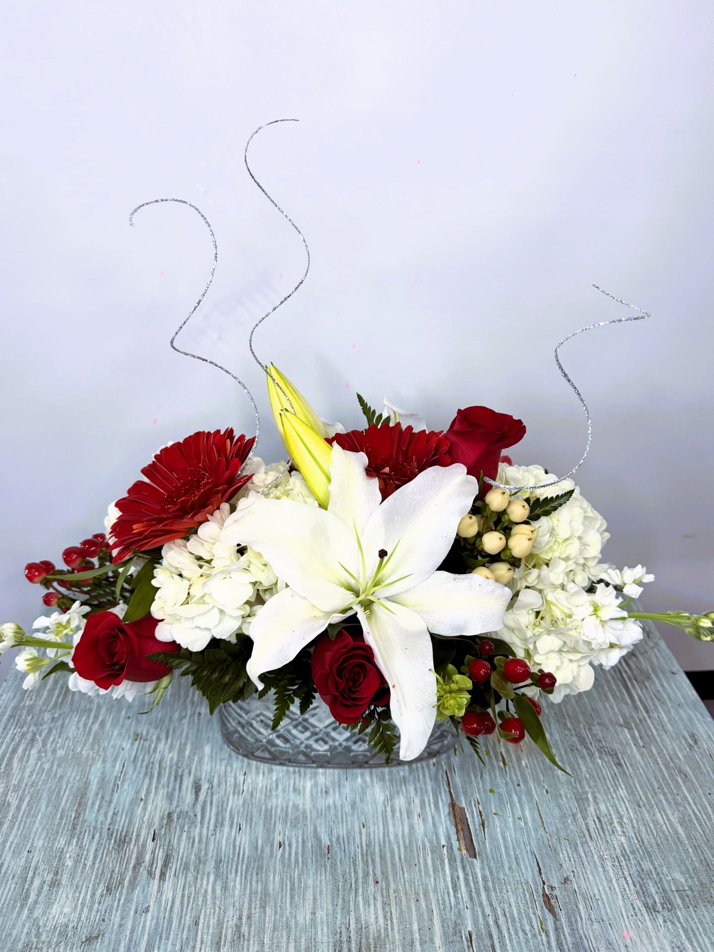 Christmas #4 - Festive arrangement designed in a silver ceramic container. Embellished with silver accents. As seen in the picture. 