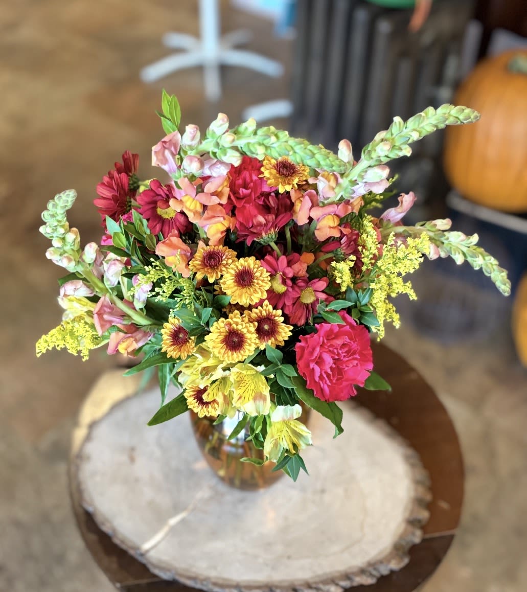 Warm Welcome - Give a warm welcome with this cheerful blend of autumn tones. Orange and pink snapdragons, sunny alstroemeria, butterscotch poms, and golden aster come together in a glowing mix that radiates comfort, gratitude, and joy.