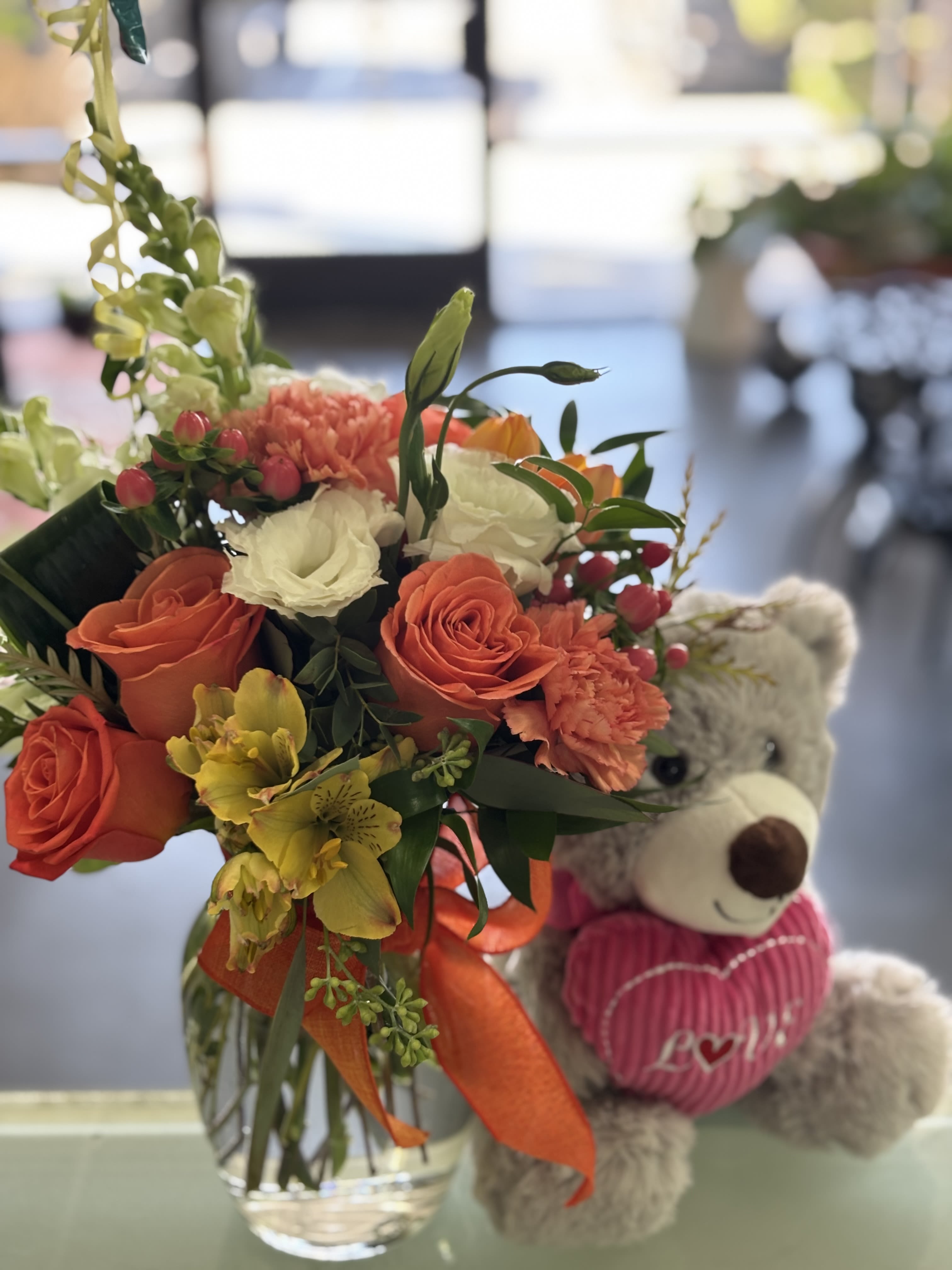 Teddie - White Snapdragons, Yellow Alstroemeria, Orange Carnations, Orange Roses, Coffee Beans, Lisianthus, Seeded Eucalyptus,  and a small Teddy Bear.