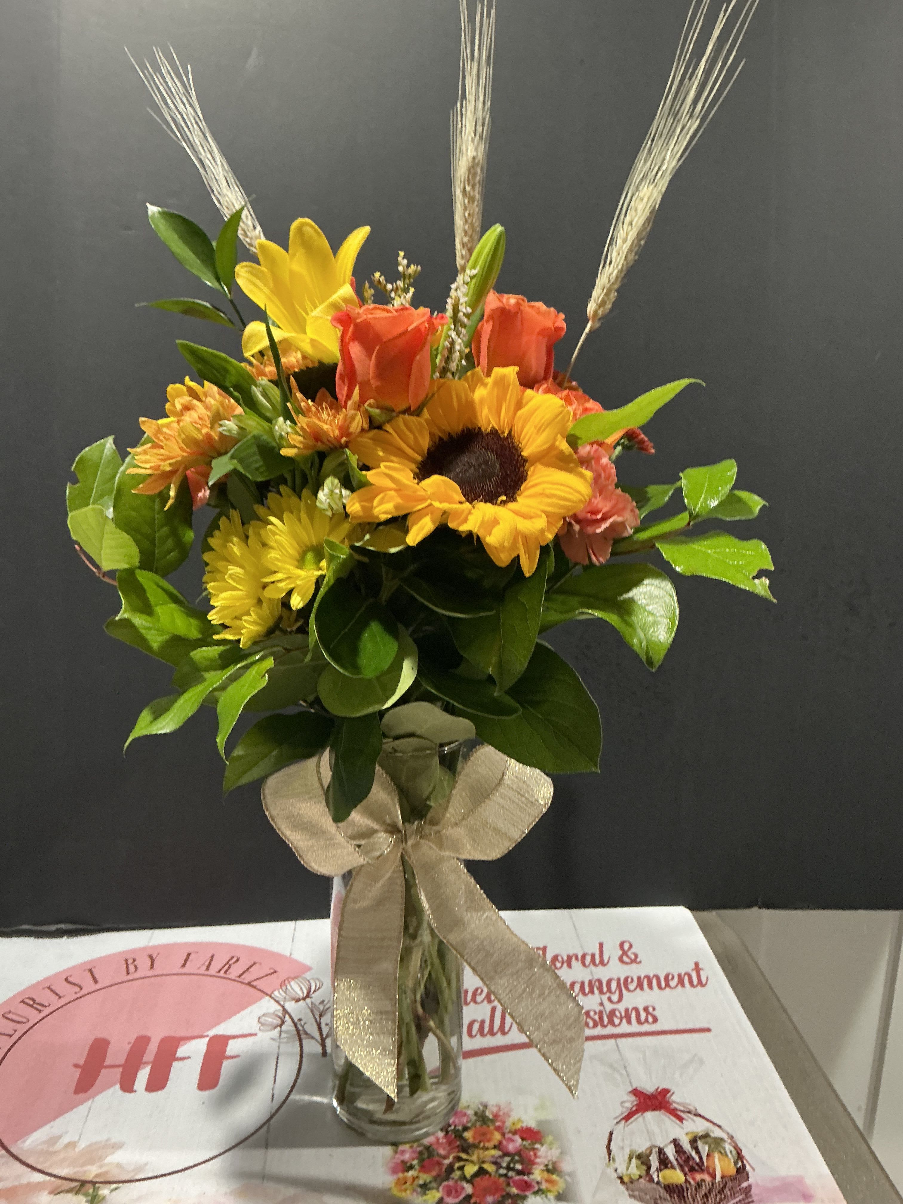 Autumn colors - The ultimate fall flower mix featuring sunflowers and a variety of orange flowers with harvest grain accents. Send this arrangement for Halloween, Thanksgiving, or to celebrate the season  