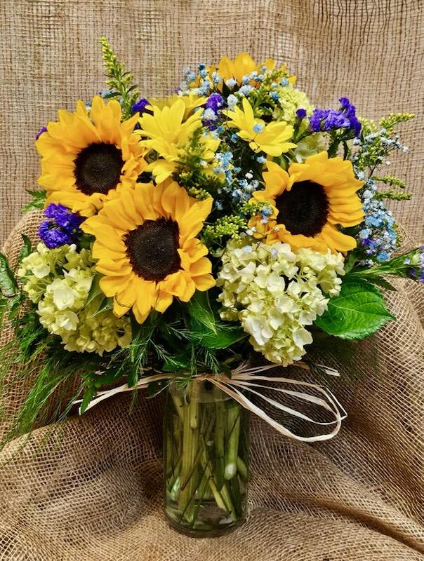 Rustic Breeze  - Like a cool breeze with a mix of rustic, A fall blend of sunflowers, hydrangeas, daisies, filled with an abundance of purple, blue and yellow filler flowers. 