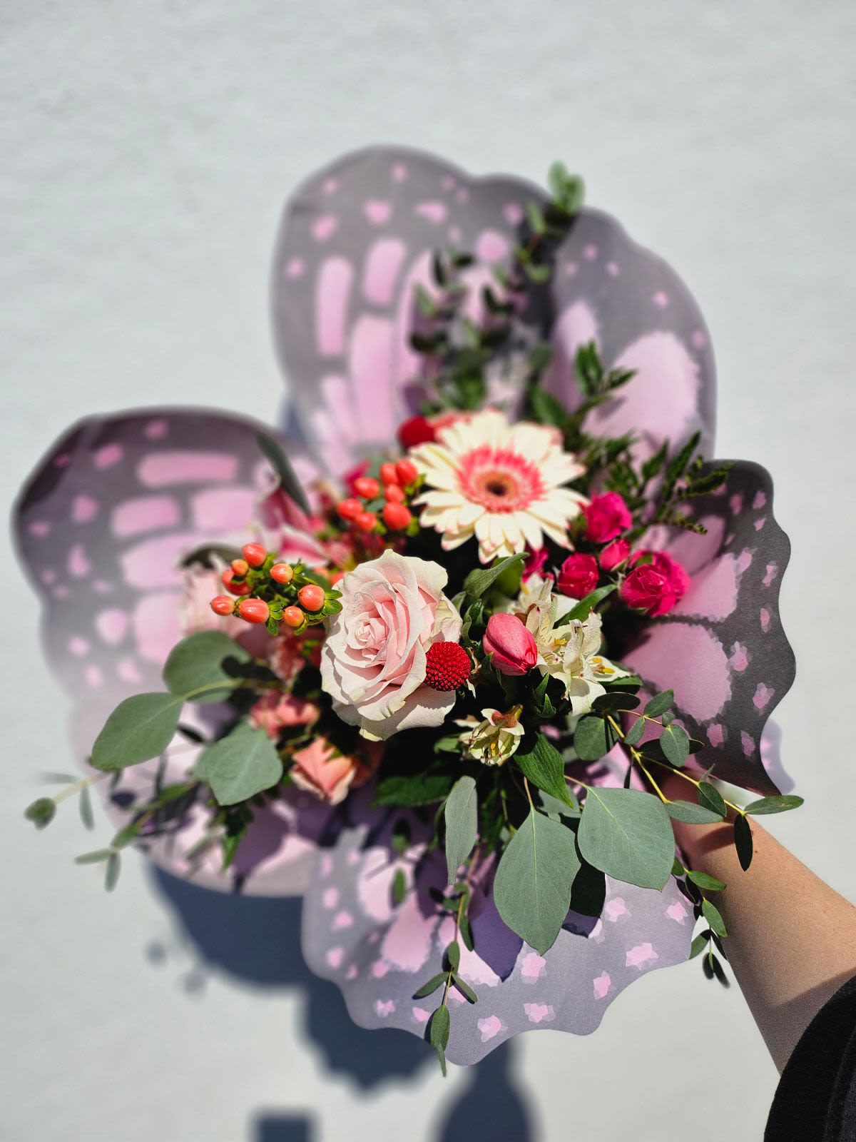 Butterfly Meadows  - A pretty pink and white mixed bouquet with assorted fresh cut flowers wrapped in premium butterfly wing printed paper. This arrangement will include a variety of flowers. Flowers may vary. Vase not included. 