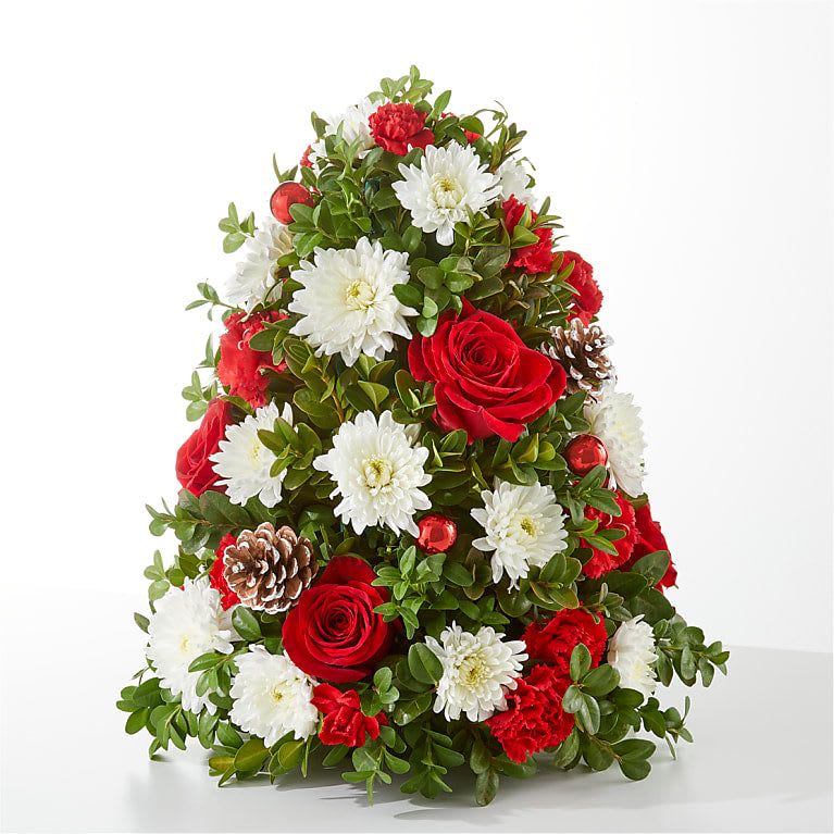 Let It Snow Tree - Bring a fresh twist to holiday décor with the Let It Snow Tree — a spirited floral tree arrangement that channels the charm of winter with elegant blooms and seasonal styling. Ideal for homes and offices across Greater Fort Lauderdale, this piece adds a bright, seasonal accent to reception desks, living rooms, or holiday gift deliveries.  Key Features &amp; Benefits: A vertical “tree”‑style arrangement combining roses, chrysanthemums and carnations, all expertly arranged for height, texture and festive appeal.   Available in three sizes:   * Standard: approx. 14″ H × 11″ W   * Deluxe: approx. 15″ H × 11″ W   * Premium: approx. **16″ H × 12″ W  * Safety notice: Some foliage may not be pet‑safe — keep the arrangement out of reach of pets.  Why It’s a Perfect Fit for DGM Flowers: This festive tree arrangement aligns beautifully with DGM Flowers’ vision of premium floral design with local flair. It offers a seasonal statement piece that appeals to your Fort Lauderdale clientele looking for standout holiday décor or meaningful gifts. Plus, its height and orientation make it a versatile choice for both desktop and side‑table placements.