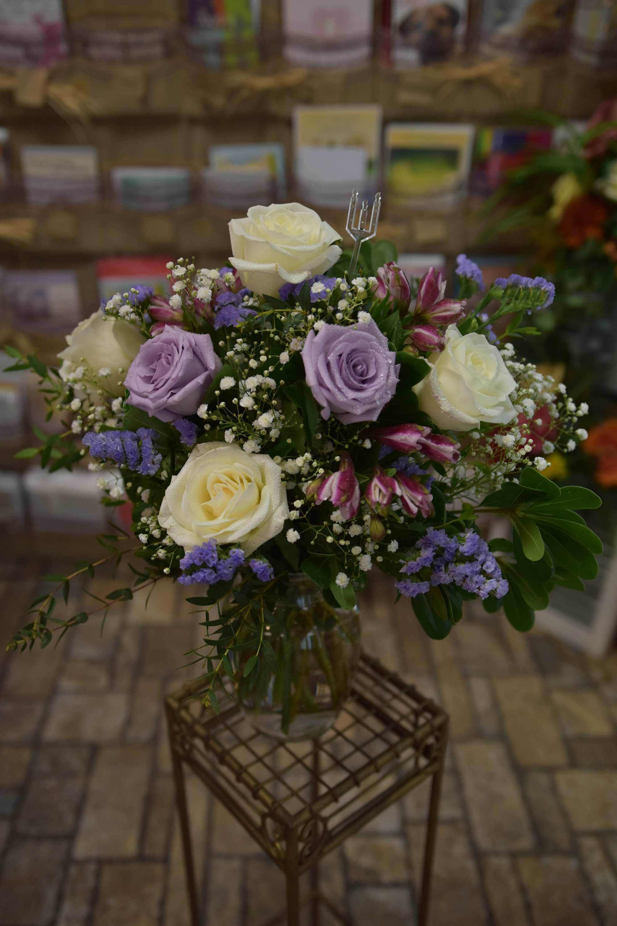 Amazing Amethyst - Tell her how much of a gem she is with this glamorous arrangement of purple and white roses, filler flowers, and assorted greenery. A dazzling way to show your love.